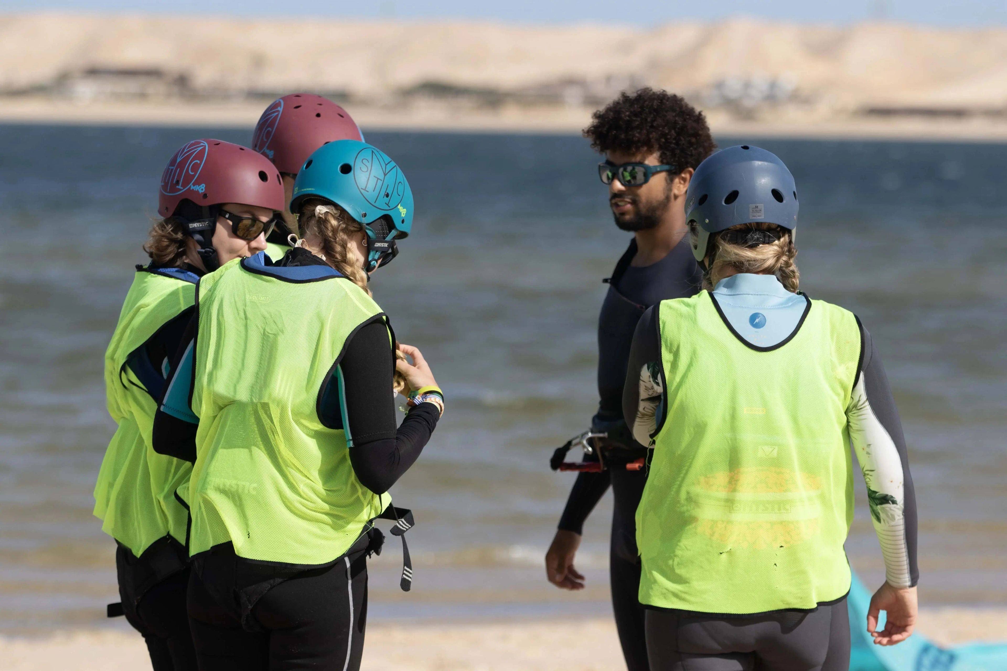 Bluboarding kitesurf instructor briefing a group of four students on the beach before a group kitesurf lesson on the Dakhla lagoon.