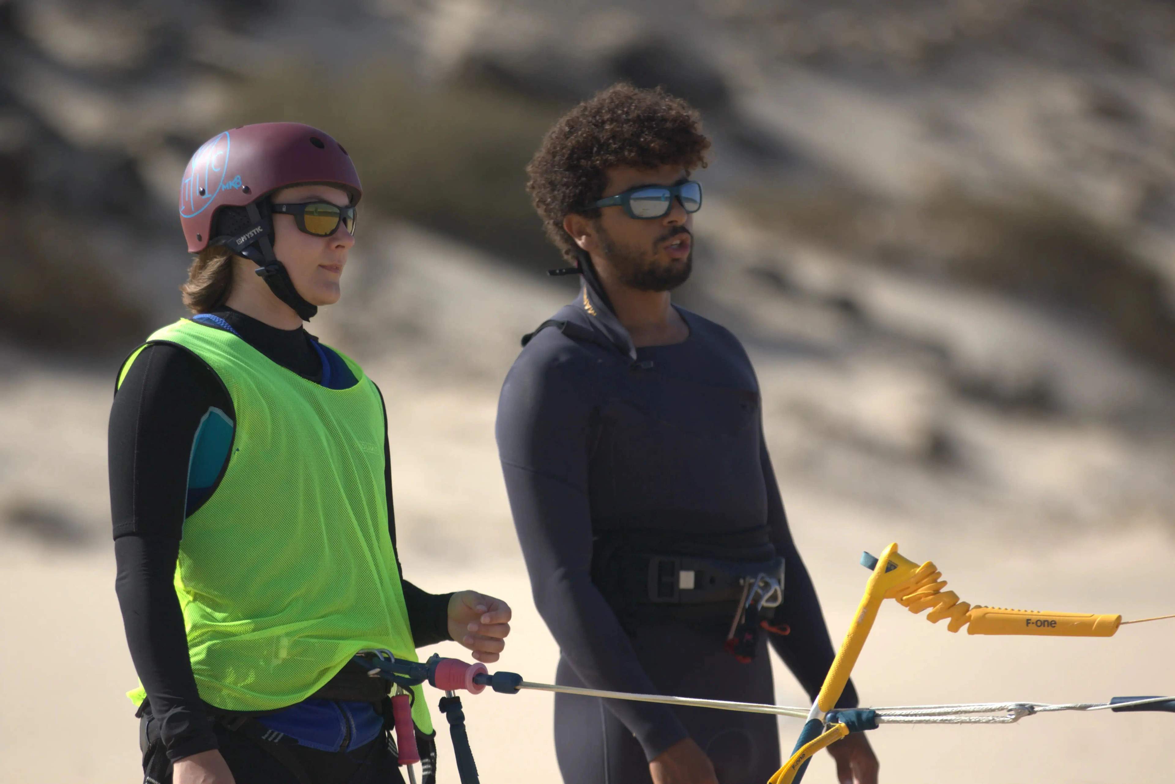 An IKO instructor giving focused, private kitesurf instruction on the shore of the Dakhla lagoon.
