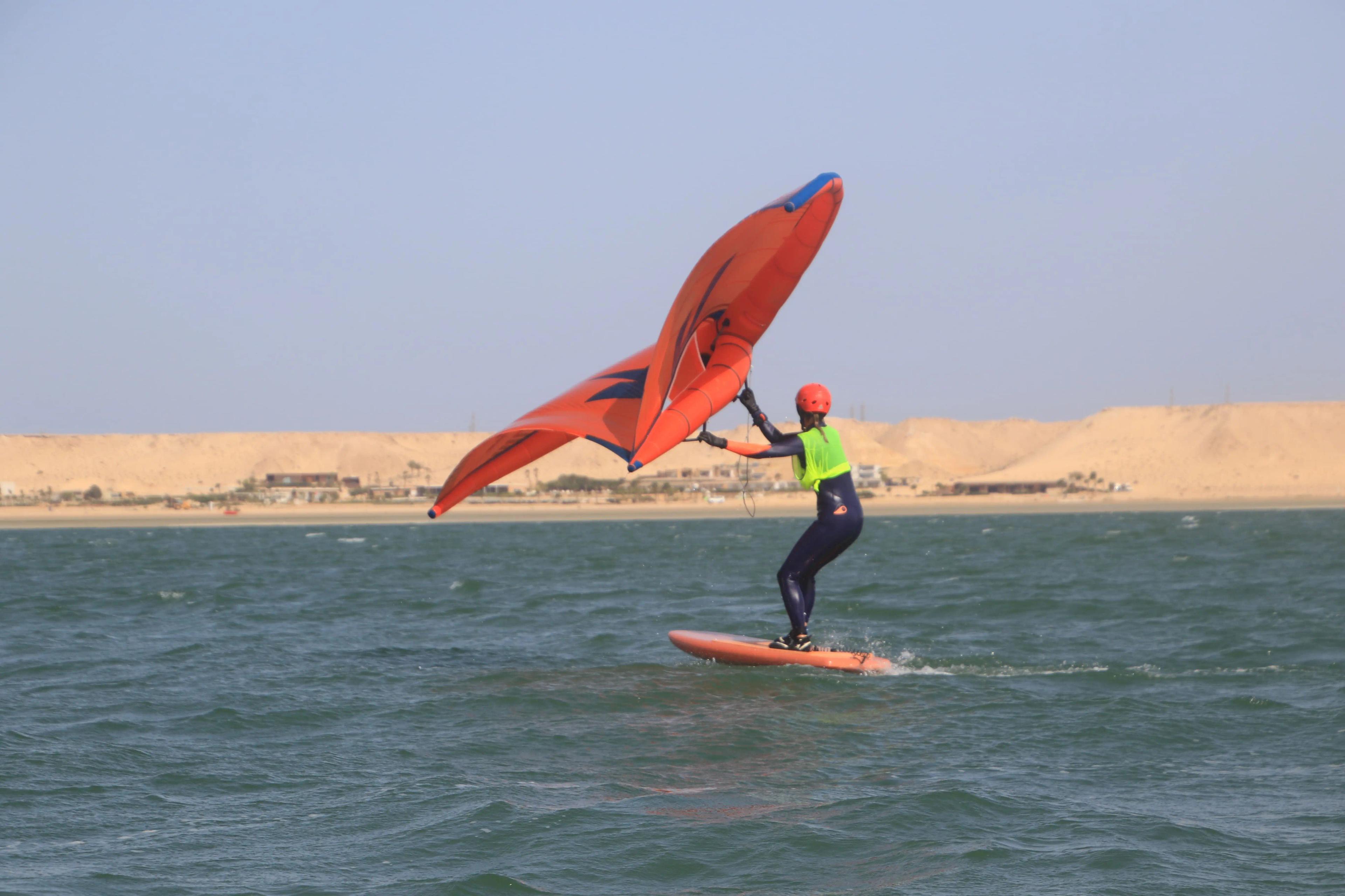 A wingfoiler experiencing the feeling of flight, gliding silently over the Dakhla lagoon with Bluboarding.