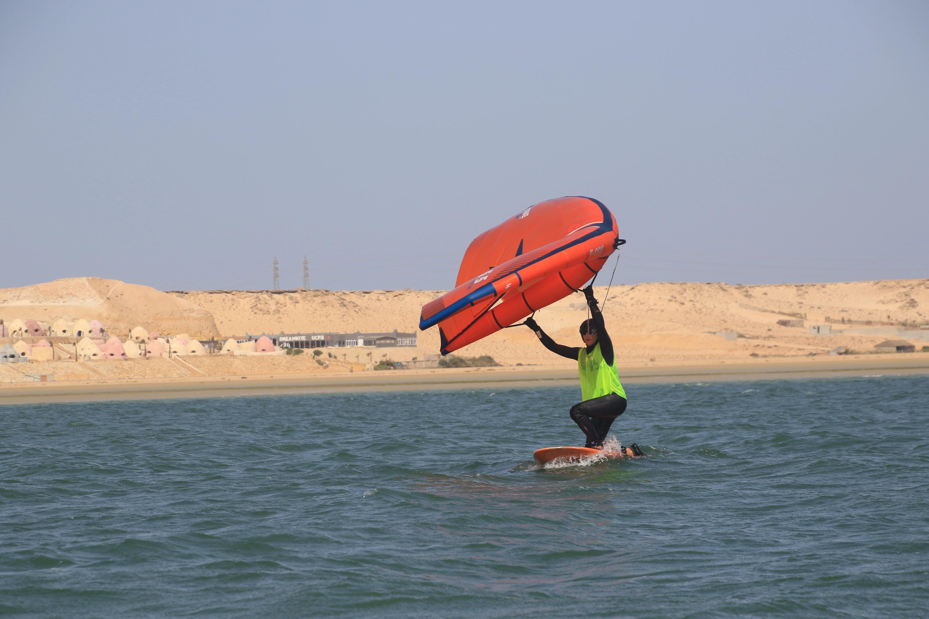 Wingfoil beginner learning to stand up on the board in Dakhla lagoon