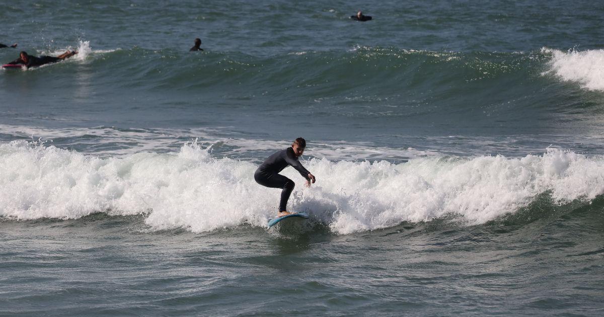 Bluboarding student catching a wave at the Point d'Or ocean break near Dakhla during an intermediate surf session.