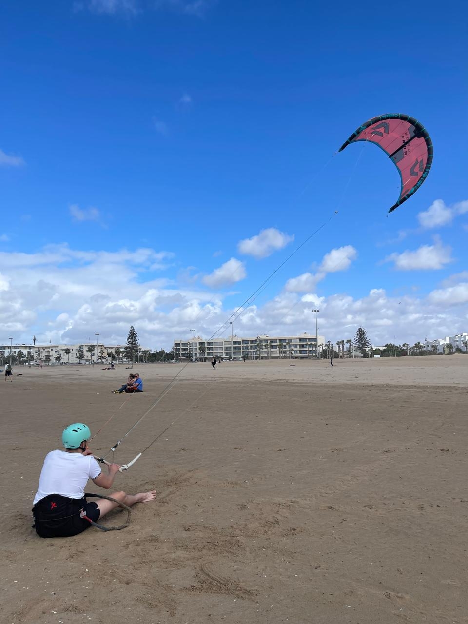 Bluboarding client practising kite control on the beach of Essaouira during a private kitesurf lesson.