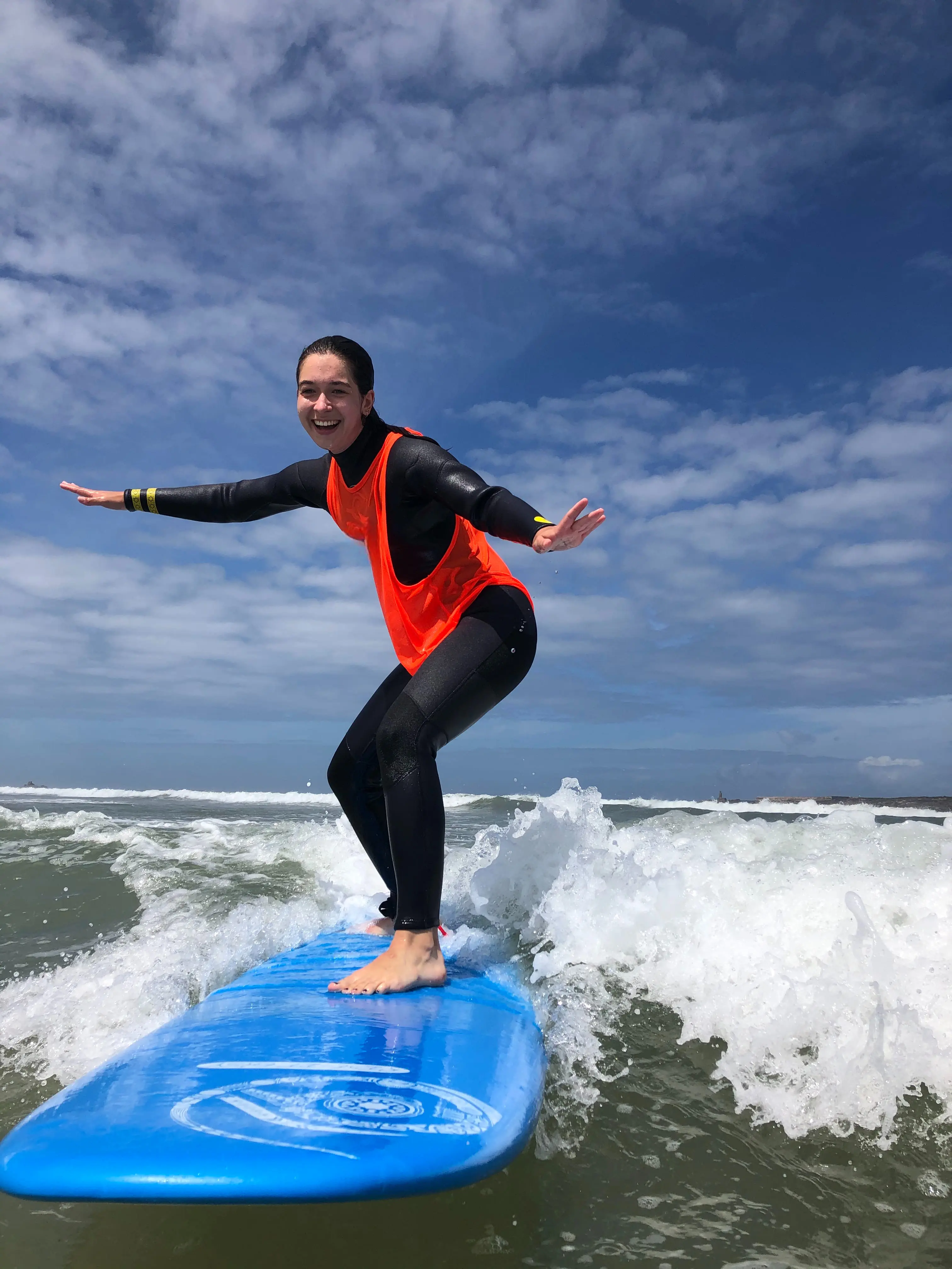 A happy beginner surfer riding their first wave during a lesson with Bluboarding in Dakhla.
