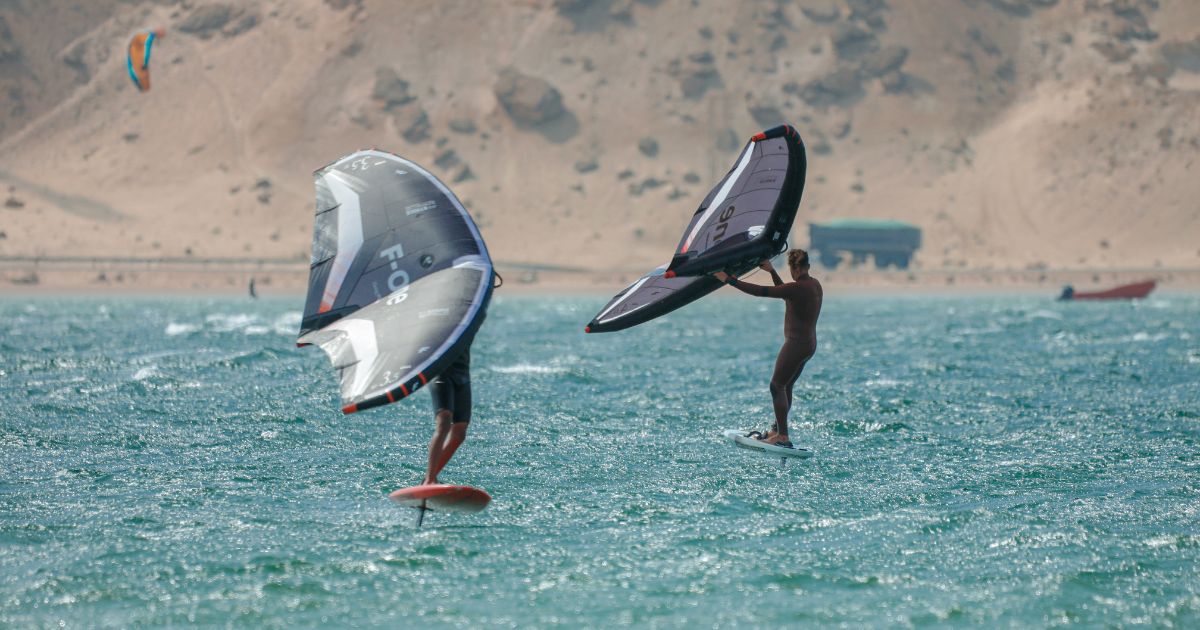Two Bluboarding clients with F-One wingfoil rental gear on the flat water of the Dakhla lagoon.